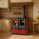 Cuisinière à bois Rosetta Maiolica rouge et noire avec four, 7,9 kW, installée dans une cuisine rustique