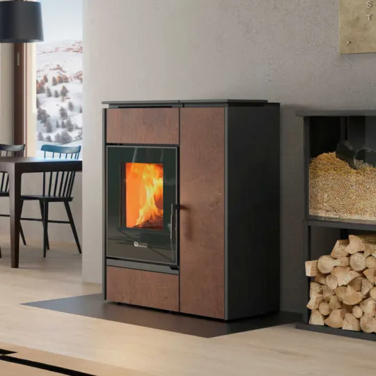 Poêle hybride Margaret 10 kW finition grès corten installé dans un salon moderne avec bûches et granulés