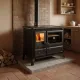 Cuisinière à bois acier noir avec four et foyer allumé installée dans une cuisine rustique