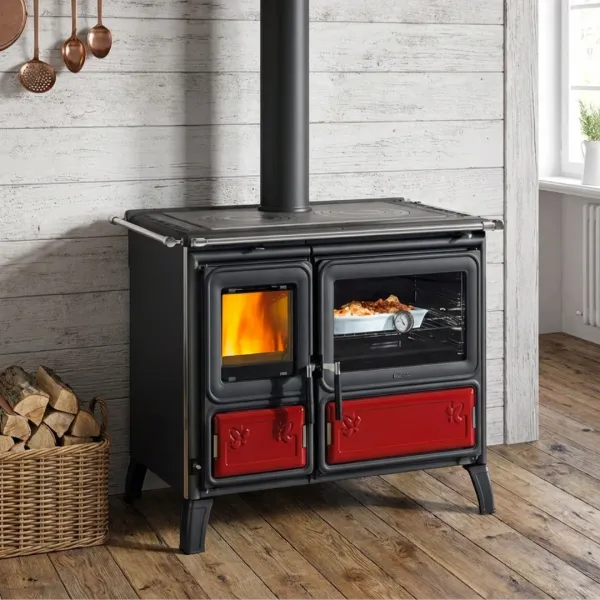 Cuisinière à bois Milly en acier noir avec four et détails rouges, installée dans une cuisine rustique