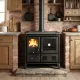 Cuisinière à bois noire avec four et foyer allumé installée dans une cuisine rustique avec mur en briques
