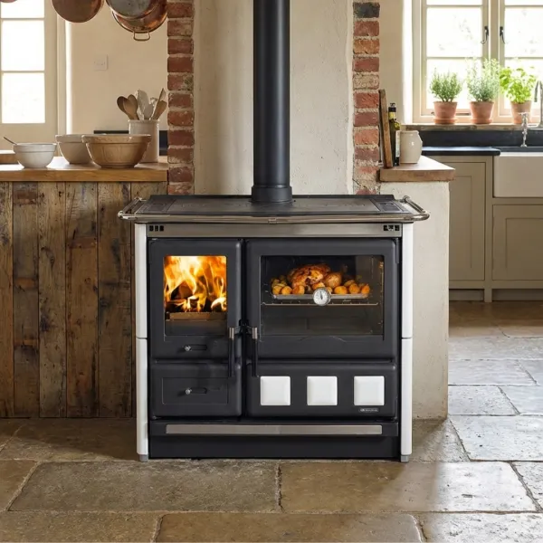 Cuisinière à bois Rosa XXL en fonte noire et blanche avec four, installée dans une cuisine rustique
