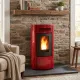 Poêle à granulés Terry Plus 12 kW rouge bordeaux installé devant cheminée en pierre avec flammes allumées