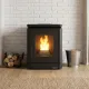 Poêle à granulés PEGGY CX 6 Kw gris anthracite allumé dans intérieur moderne avec mur de briques blanches