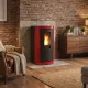 Poêle à granulés Mietta Evo rouge et noir 9 kW allumé dans un salon avec mur en briques