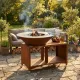 Brasero BBQ plancha Brasinox Fiesta Island Ø75 cm allumé dans un jardin