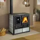 Cuisinière à bois Rosa Sinistra Reverse 8 kW raccordée à un conduit dans un intérieur moderne