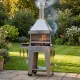 Barbecue au charbon Foxy en inox en fonctionnement dans un jardin, avec flammes visibles dans le foyer