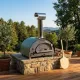 Four à pizza bois Arde Baby vert installé sur une terrasse